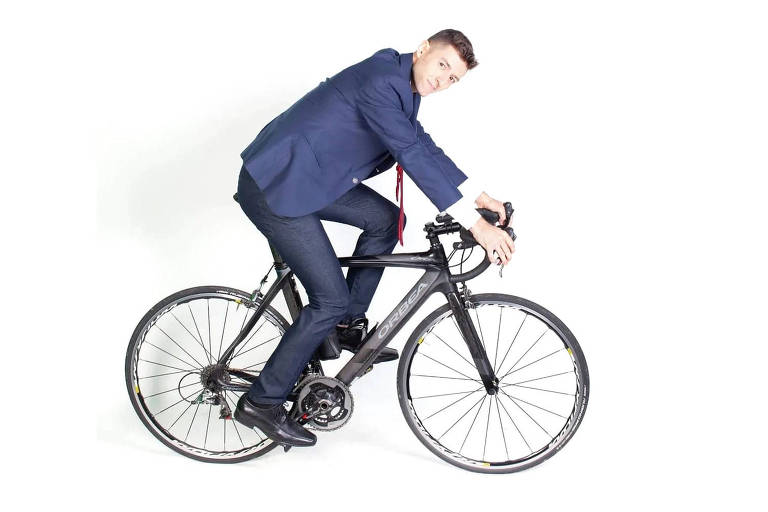 Vestindo terno, Renan posa sobre bicicleta