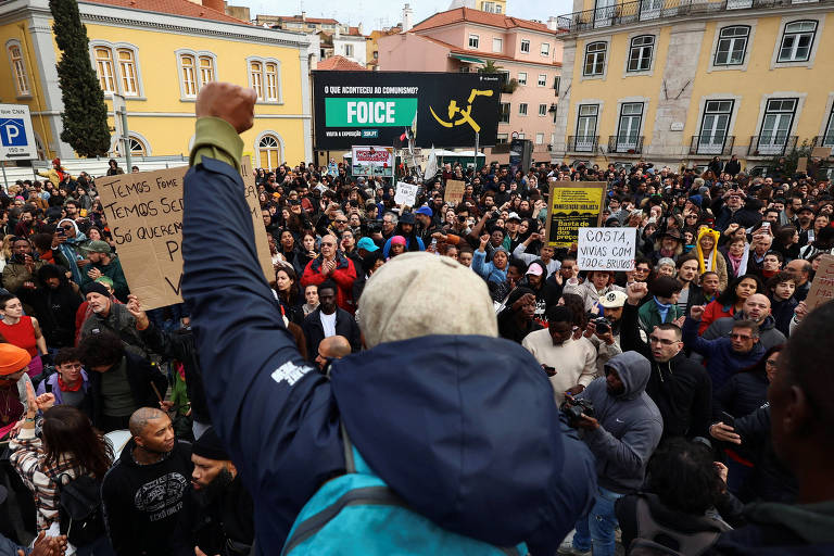Imagem mostra multidão de manifestantes, sendo alguns com cartazes, protestando nas ruas de Lisboa