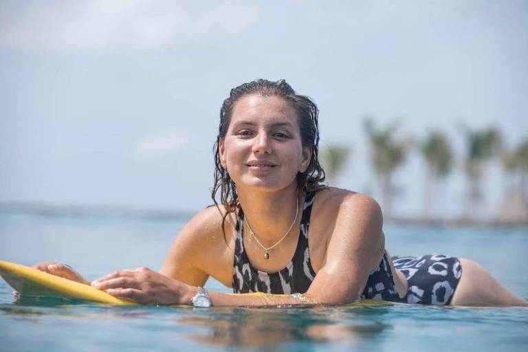 A surfista Maya Gabeira em cima da prancha amarela