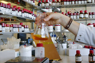 FILE PHOTO: An employee mixes liquid fragrances in a bottle in a laboratory of Swiss flavours and fragrances maker Givaudan in Duebendorf