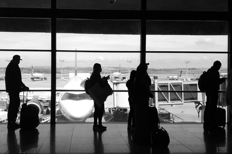 Passageiros fazem fila para entrar em um voo no Aeroporto Internacional de Confins, próximo a Belo Horizonte