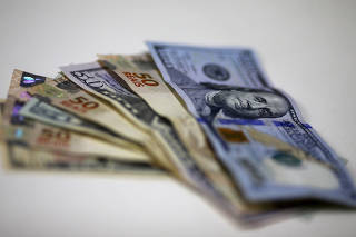 FILE PHOTO: Brazilian Real and U.S. dollar notes are pictured at a currency exchange office in Rio de Janeiro