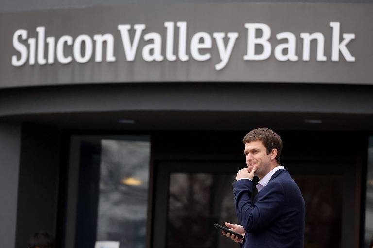 homem diante da fachada de um prédio em que se lê Silicon Valley Bank