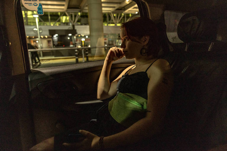 Mulher sentada em banco de carro olhando pela janela