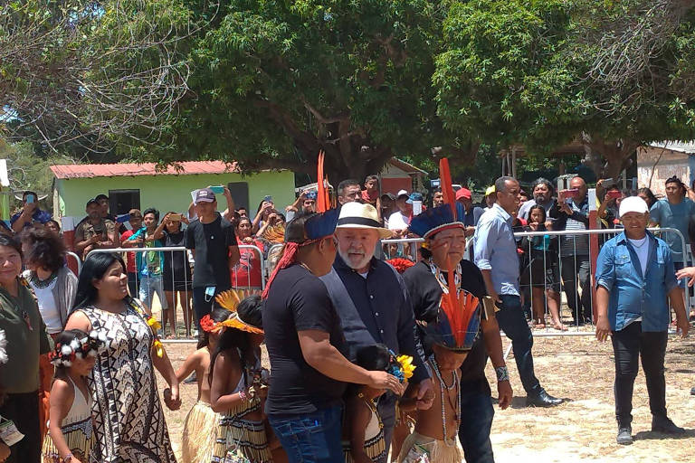 Lula, usando de chapéu, conversa com lideranças indígenas