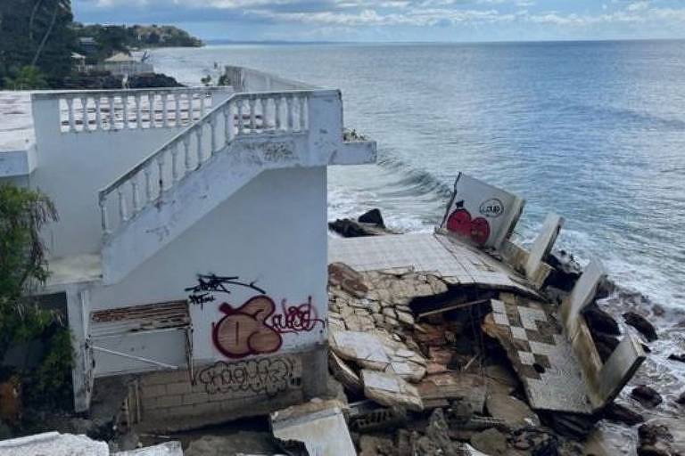 a foto mostra uma escada que conduz ao segundo andar de uma casa que foi destruída pela ação do mar