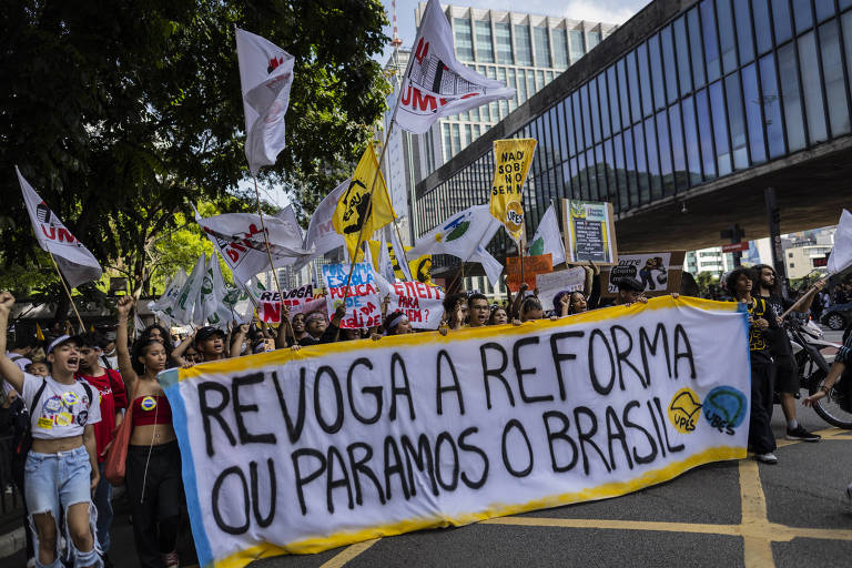 manifestação com varias pessoas e bandeiras e uma faixa com a frase: revoga a reforma ou paramos o Brasil