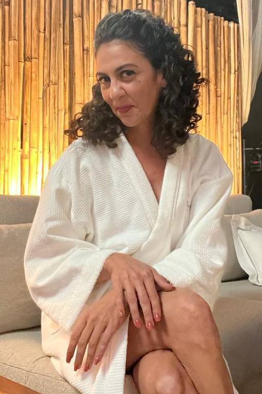 A atriz Clarissa Pinheiro veste um roupão branco e usa maquiagem, caracterizada para a personagem Tereza de Mar do Sertão