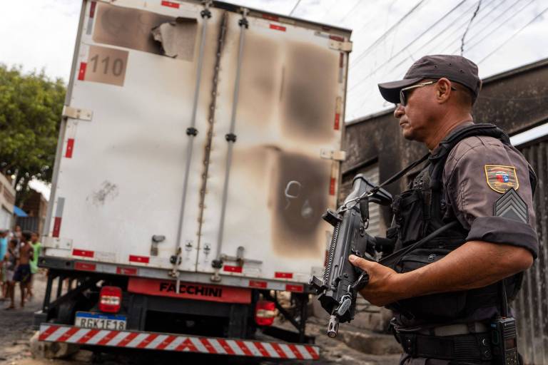 Policial faz guarda ao lado de caminhã incendiado em Natal; o Rio Grande do Norte teve a terceira noite e madrugada de violência com ataques na capital e diversas outras cidades