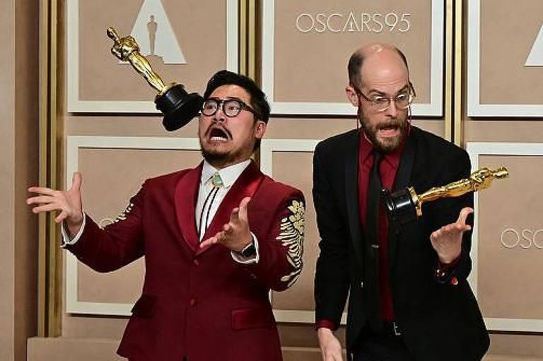 A dupla de cineastas Daniel Kwan e Daniel Scheinert brincam com estatuetas do Oscar as jogando para cima