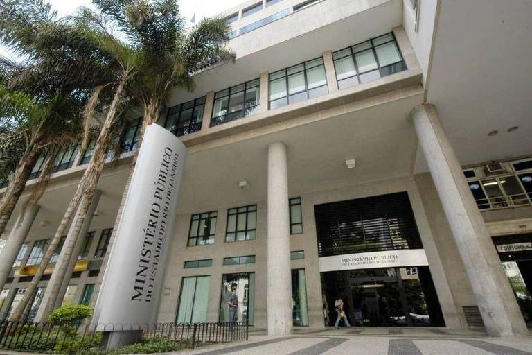 prédio com dois andares, com colunas altas e palmeiras na calçada. Uma placa indica que o local é o Ministério Público do Rio de Janeiro