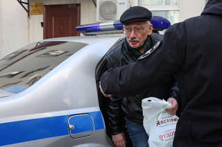 Oleg Orlov, chairman of Russian human rights centre Memorial, gets out of a car while being delivered to Russian Investigative Committee in Moscow