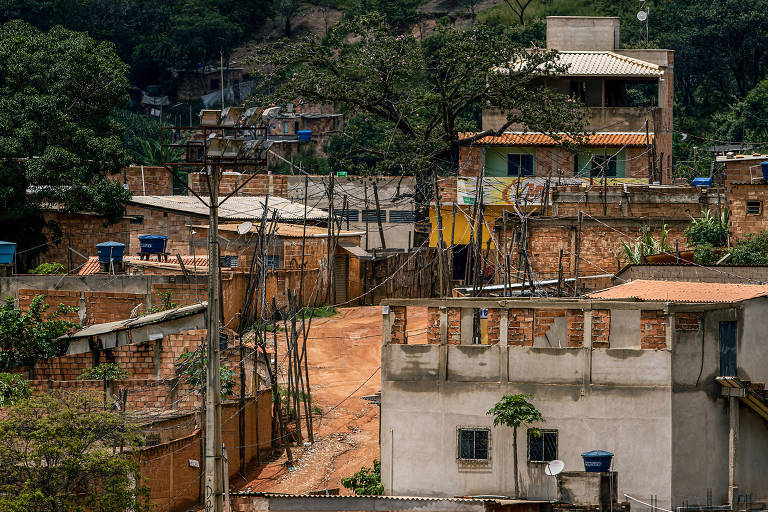 foto mostra casas e rua de terra na Ocupação Izidora, em Belo Horizonte. É possível ver lixo na rua 