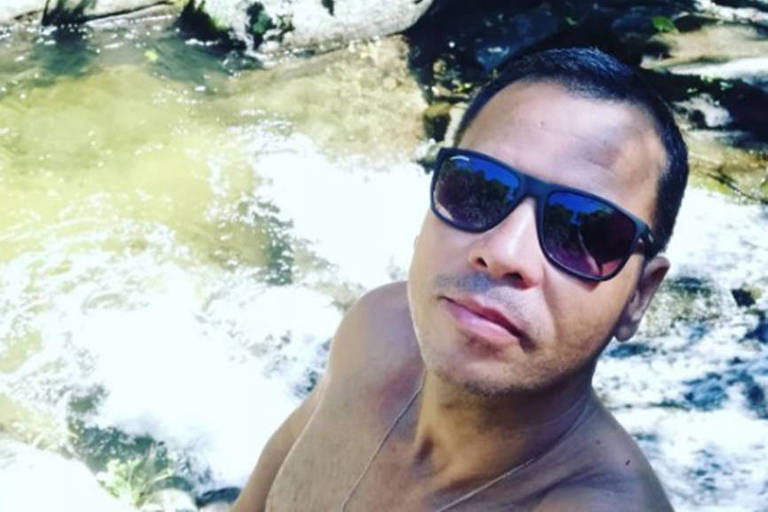 Imagem colorida mostra o torcedor Eder Santos em uma cachoeira. Ele aparece com o rosto de frente usando óculos escuros. 
