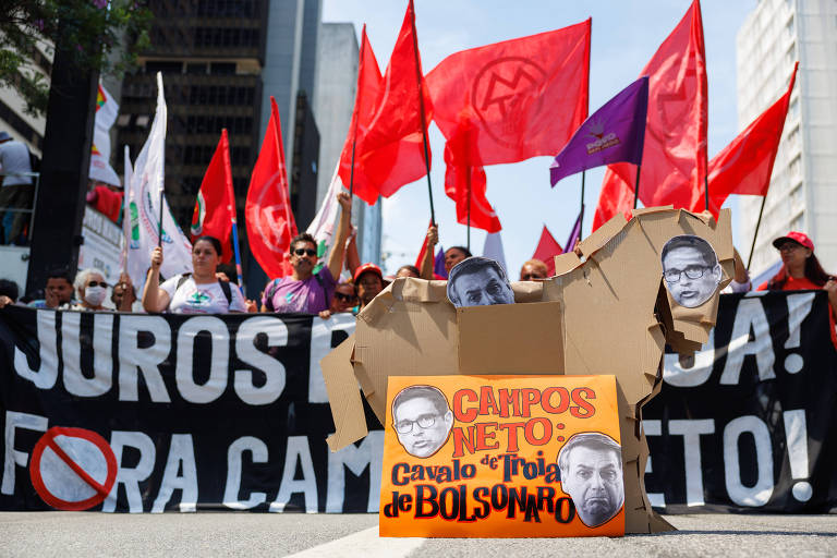 Manifestantes de centrais sindicais levam "cavalo de Tróia" de papelão com fotos de Roberto Campos Neto e Jair Bolsonaro em protestos contra política de juros do BC, em São Paulo
