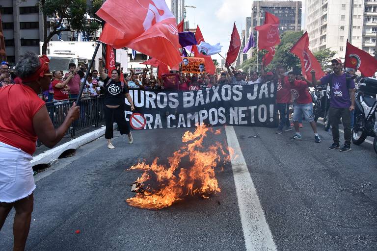 Manifestantes ateiam fogo em "cavalo de Tróia" de papelão com as fotos de Roberto Campos Neto e Jair Bolsonaro