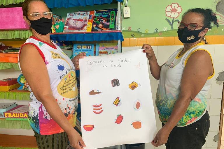 Merendeiras mostram quadro explicativo com produtos de agricultura familiar orgânica utilizados no preparo da merenda em escola em Santa Luzia do Itanhy (Sergipe)