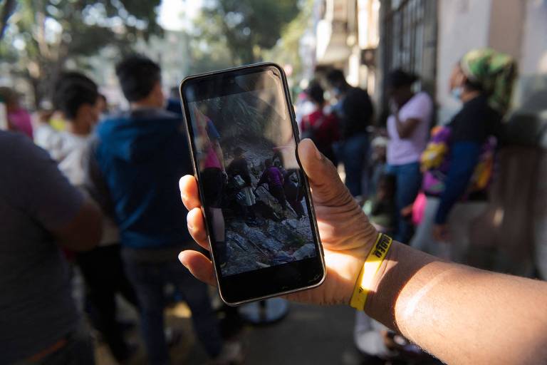a foto mostra um celular onde passa um vídeo no tiktok com pessoas atravessando por uma região árida