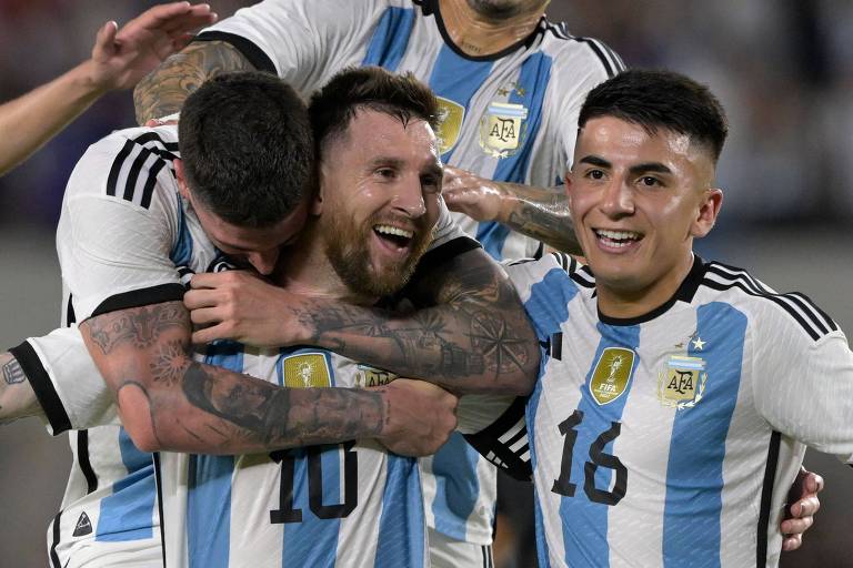 Messi é abraçado por companheiros após marcar pela Argentina