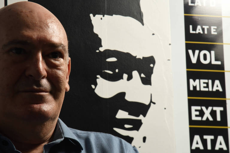 Andres Rueda com pintura de Pelé ao fundo em sua sala no CT do Santos