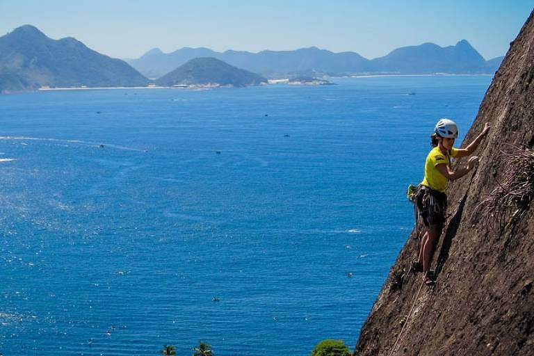 Mulher escala a pedra da Urca, no Rio de Janeiro