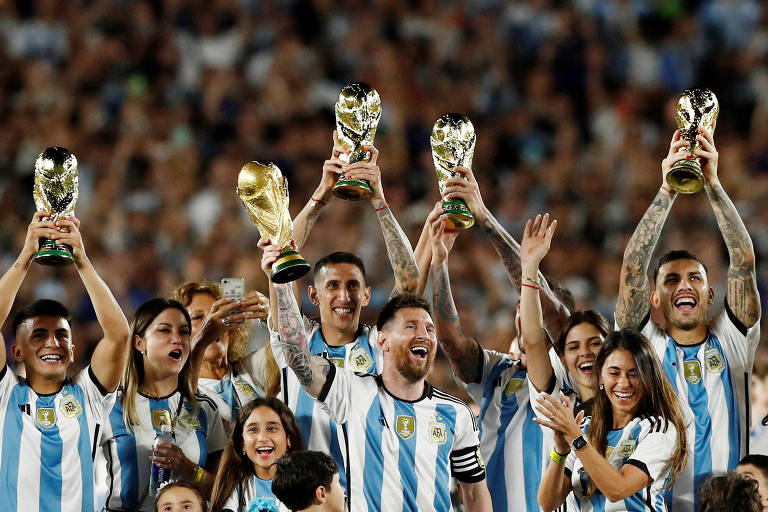 Jogadores argentinos levantam réplicas da taça conquistada na Copa do Mundo 2022, no Qatar, em amistoso contra o Panamá no estádio Monumental de Núñez, em Buenos Aires