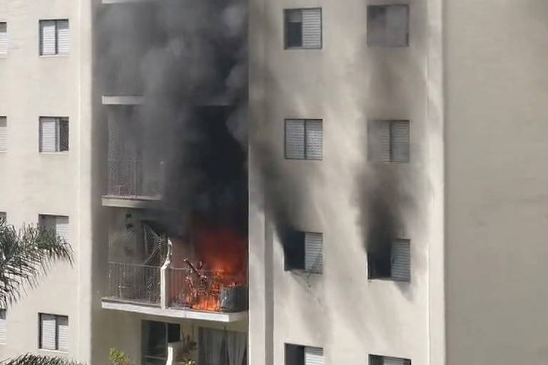foto mostra incendio em apartamento de prédio residencial. o fogo sai pela varanda e há fumaça saindo por duas janelas do lado direito da varanda