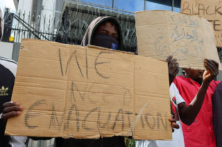 African migrants carry banners during a protest in Tunis