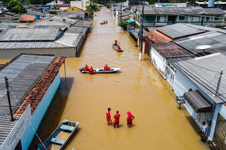 Firefighters inspect a flooded residential area after heavy rains in Rio Branco