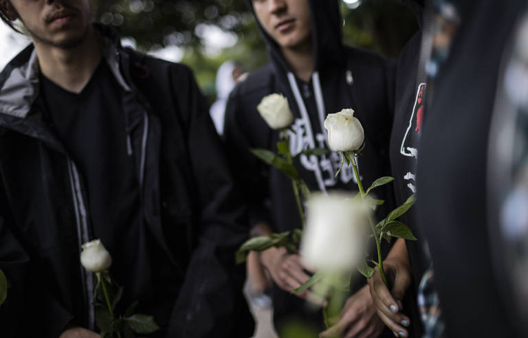 Na foto, alunos carregam rosas brancas em homenagem à professora Elisabeth Tenreiro