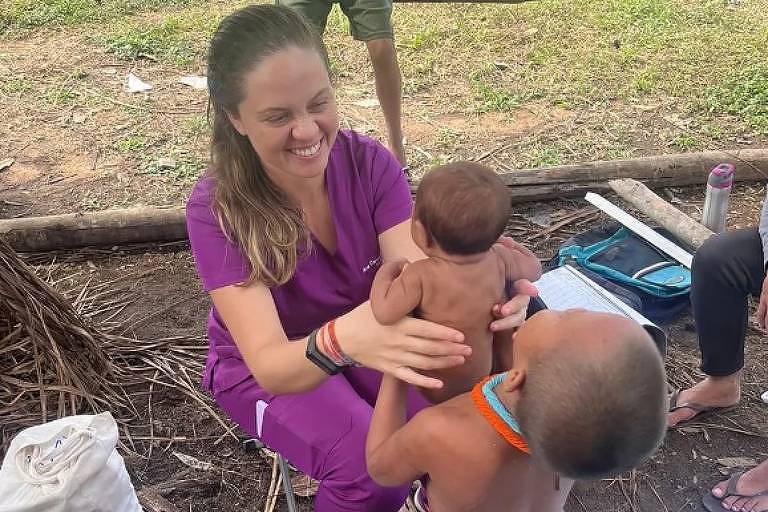 Médica sorri para bebê indígena