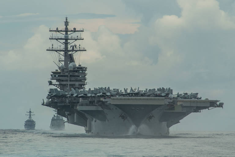 O porta-aviões americano USS Ronald Reagan é escoltado no mar das Filipinas por um destróier dos EUA e outro, do Japão