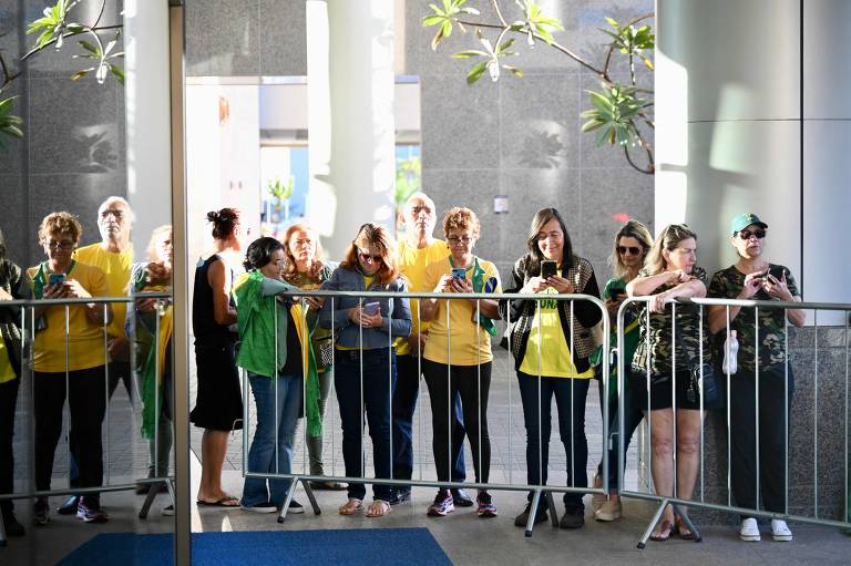 Apoiadores do ex-presidente Jair Bolsonaro aguardam sua chegada à sede do PL, em Brasília