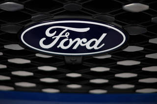 FILE PHOTO: A Ford badge is seen on the grill of an E-transit concept vehicle during a press event at the Ford Halewood transmissions plant in Liverpool