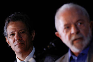FILE PHOTO: Brazil's economy minister nominee Fernando Haddad looks on as President-elect Luiz Inacio Lula da Silva talks during a news conference at the transition government building in Brasilia