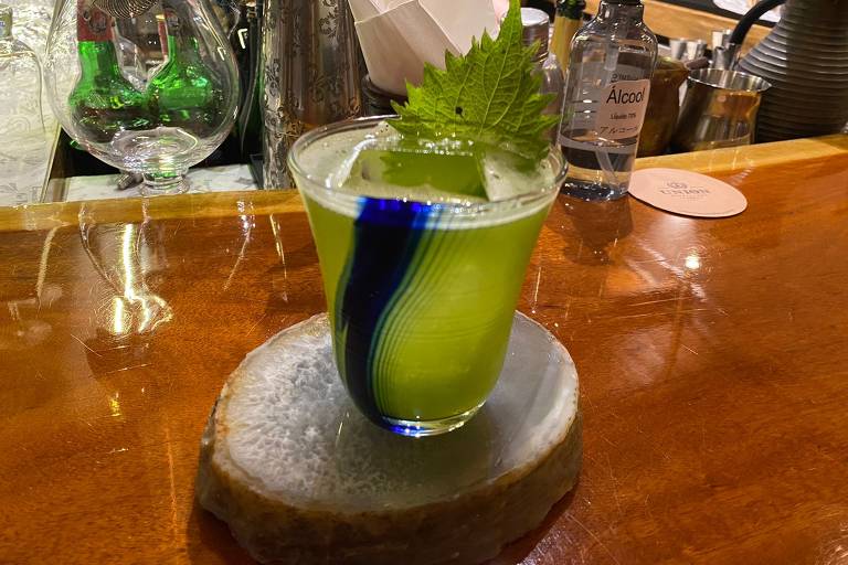 Drinque verde e adornado por uma folha de shissô