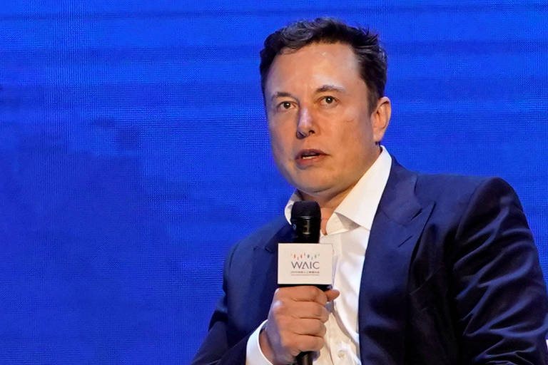 Elon Musk em palestra na Conferência Mundial de Inteligência Artificial, realizada em Shangai, na China, em 2019. Musk veste terno marinho e camisa branca, sem gravata.