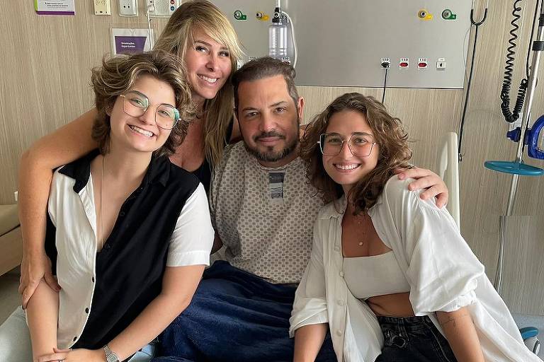 Conrado aparece no hospital com Andréa e as filhas