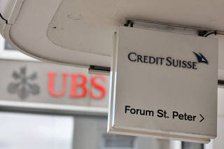 FILE PHOTO: Logos of Swiss bank UBS and Credit Suisse in Zurich
