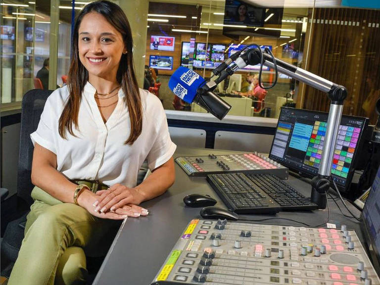A jornalista Carla Bigatto na mesa de edição da rádio BandNews