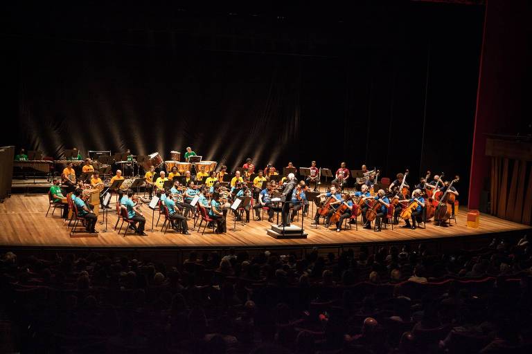 Em foto colorida, a Orquestra Sinfônica Brasileira aparece no palco