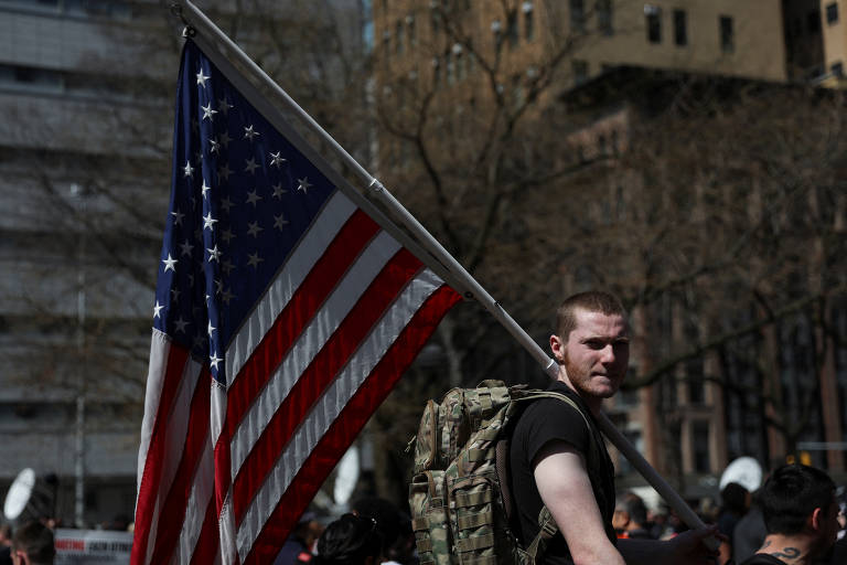 Apoiador de Trump segura uma bandeira dos EUA em apoio ao ex-presidente