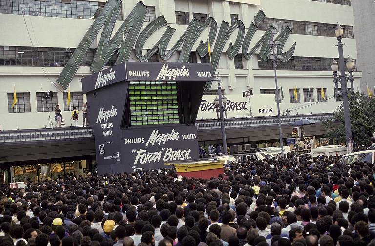 Multidão acompanha jogo da Copa do Mundo de 1990, na Italia, em telão instalado na praça Ramos de Azevedo pelo Mappin.