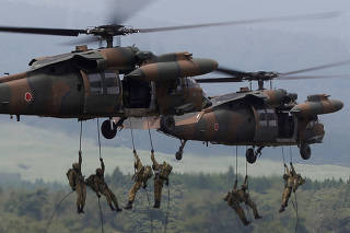 Japanese Ground Self-Defense Force soldiers rappel from UH-60 Black Hawk helicopters during an annual training session near Mount Fuji at Higashifuji training field in Gotemba