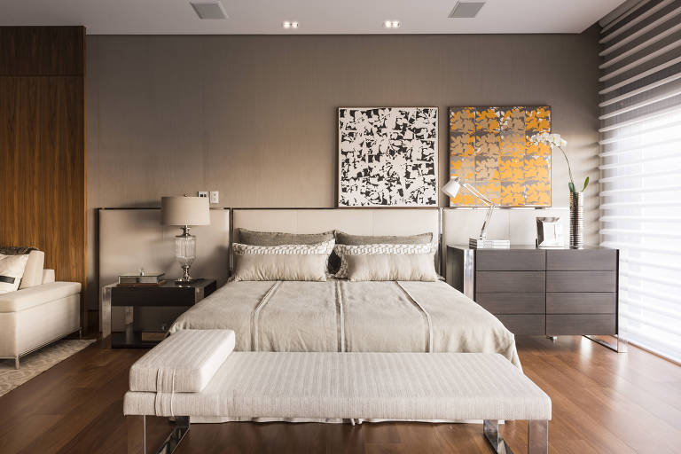 Em quarto de casa, os quadros abstratos estão apoiados no painel da cabeceira da cama, de forma descentralizada