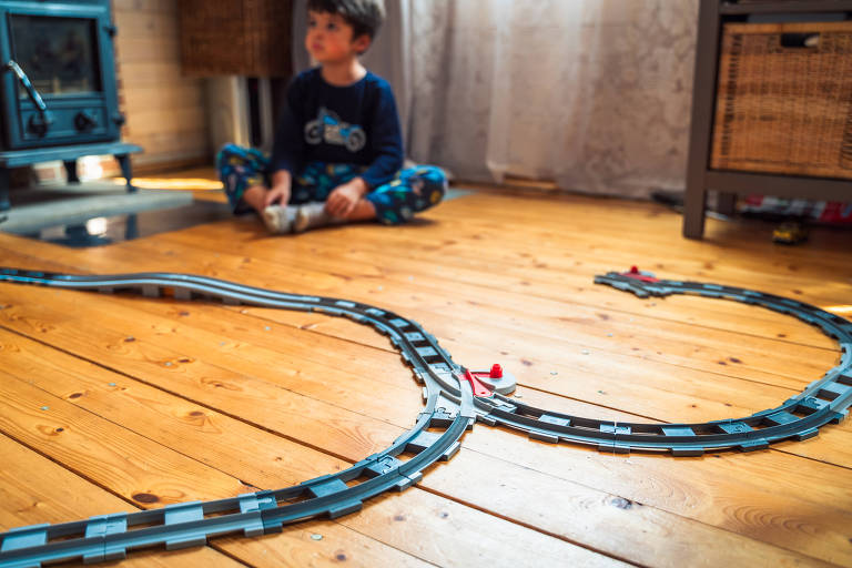 Meninas, irmãs brincam de construtoras infantis, constroem ferrovia de brinquedo, ferrovia com tijolos de Lego
