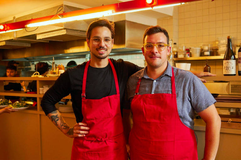 A foto mostra dois chefs de aventais vermelhos abraçados: Danillo Coelho, do restaurante Mila, e o chef italiano Antonio Maiolica