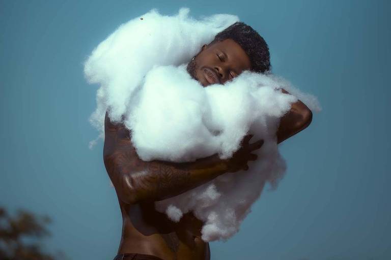 retrato de homem negro envolto em tecido similar ao algodão para imitar uma nuvem