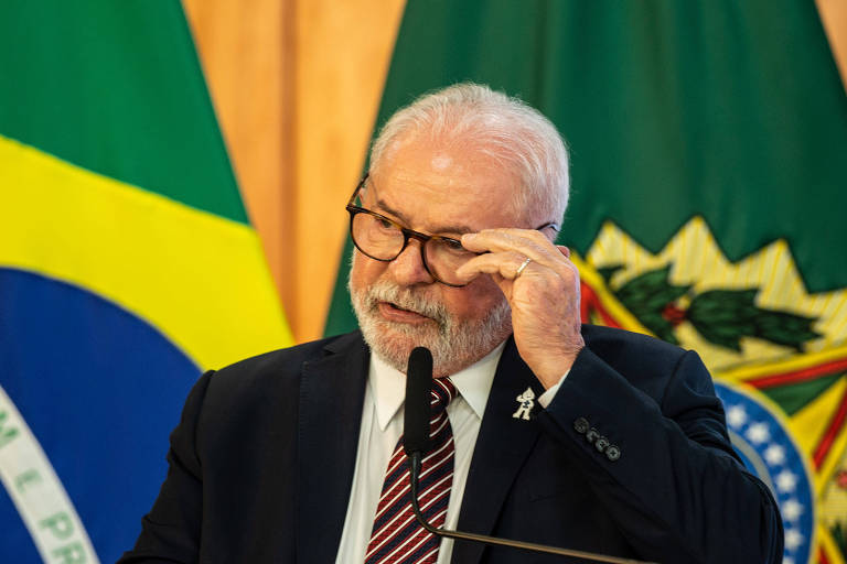 O presidente Luiz Inácio Lula da Silva em reunião ministerial dos 100 dias de governo, no Palácio do Planalto; ele está sozinho na foto com a mão no óculos