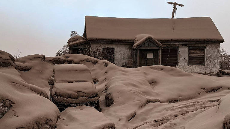 Casa e carro cobertos por cinza vulcânica após a erupção do vulcão Shiveluch na região de Kamtchatka, na Rússia